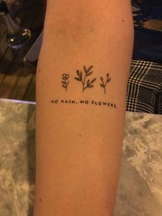 a person with a tattoo on their arm that says, no rain, no flowers