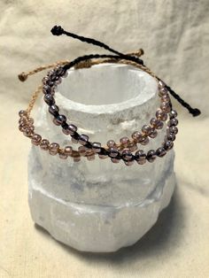 Pale pink iridescent seed beads braided onto black and tan waxed polyester cord with a square knot slide closure. Pink Iridescent, Seed Bead Bracelets, Pink Bracelet, Seed Bead