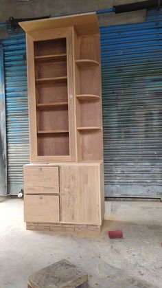 a wooden cabinet sitting in front of a garage door