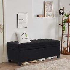 a living room with a black bench and rugs on the floor in front of it