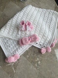 two crocheted baby blankets with pink bows on them