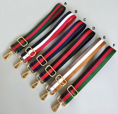 four different colored belts with gold buckles on each side and one black, white, red, green, blue, yellow