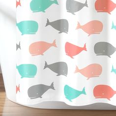 a shower curtain with different colored whales on it