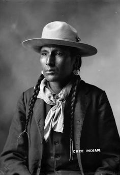 an old black and white photo of a man with braids in his hair wearing a hat