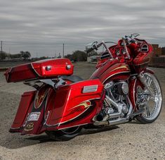 a red motorcycle parked on top of a gravel road