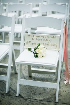 there are white chairs that have been decorated with flowers and ribbons on the back of them