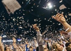 a group of people throwing confetti into the air at a convention or event