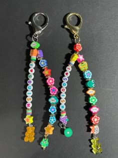 two pairs of colorful beaded key chains on a black surface with metal clippings