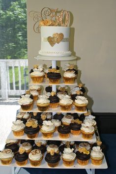 a tiered cake with cupcakes on it