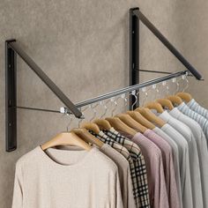 a rack with clothes hanging on it next to a wall