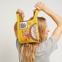 a woman is holding up a bag made out of cereal