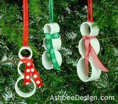 three christmas ornaments hanging from a tree with red, green and white ribbons on them