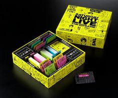 a yellow box filled with lots of different types of eraser pastes on top of a black table