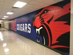 an empty hallway in a high school with murals on the wall