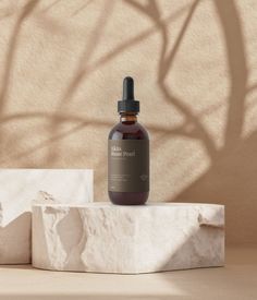 a bottle of vitamin oil sitting on top of a block of paper next to a plant