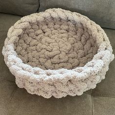 a dog bed made out of yarn sitting on a couch