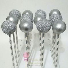 there are silver and white striped candy sticks with glitter balls on them in the shape of snowflakes