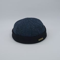 This beanie is a limited edition prototype that has yet to be released for purchase, making it a true gem for aficionados of this design. Don't miss the chance to become the fortunate owner of this one-of-a-kind and exclusive limited edition cap. Introducing the Docker cap, a refined and practical accessory crafted from the finest Harris Tweed fabric, comprised of 100% pure wool. Harris Tweed is renowned for its unparalleled quality among all woolen textiles. This cap has been meticulously desig Blue Wool Cap, Navy Flat Cap For Winter, Navy Wool Casual Hat, Outdoor Cap With Herringbone Pattern, Casual Navy Wool Hat, Blue Outdoor Beanie Hat, Outdoor Blue Beanie Hat, Navy Wool Cap, Casual Brimmed Hat With Herringbone Pattern