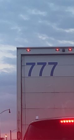 a truck with the number 777 on it's back lights are shown at dusk