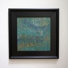 a painting hanging on the wall in front of a white wall with a black frame