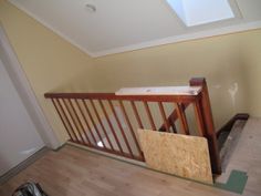 a room with hard wood flooring and an unfinished stair case next to a pair of shoes