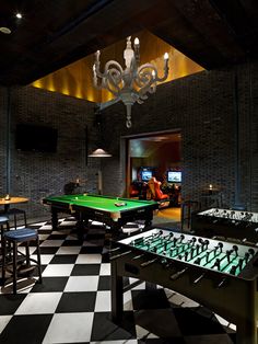 a pool table and foosball in a room with black and white checkered flooring