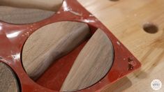 a pair of glasses sitting on top of a wooden table next to holes in the wood