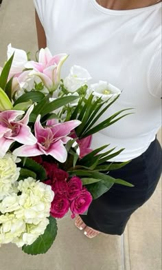 a woman holding a bouquet of flowers in her hands