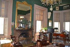 a living room filled with furniture and a fire place under a chandelier hanging from the ceiling