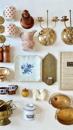 there are many different items on the table together, including cups and saucers with spoons