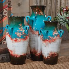 three blue and white vases sitting on top of a rug