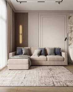 a living room with a couch, rug and lights on the wall above it in front of a large window