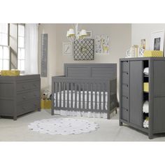 a baby's nursery room with gray furniture and yellow accents on the walls, along with a white rug