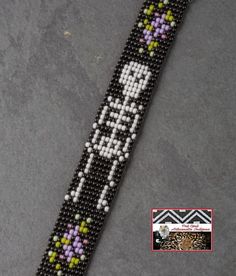 a black beaded bracelet with flowers on it and a cross charm hanging from the clasp