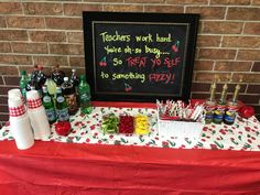 a table topped with lots of food and drinks next to a chalkboard that says teachers work hard