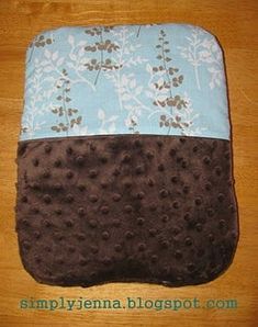 a blue and brown pillow sitting on top of a wooden table