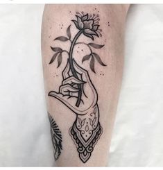 a black and white photo of a woman's arm with a flower on it