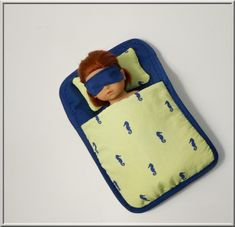 a doll in a sleeping bag with a blindfold