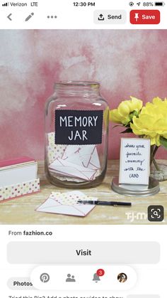 an image of a jar with some cards in it and flowers on the table next to it