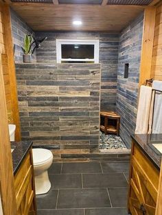 a bathroom with wood paneling and tile flooring on the walls, along with a tv mounted to the wall