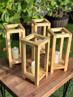 three wooden lanterns sitting on top of a table