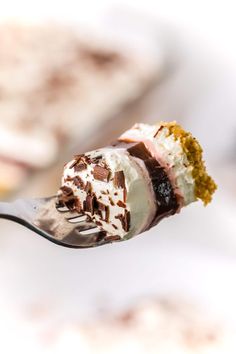 a spoon full of ice cream and cake on top of it's fork with a bite taken out of it