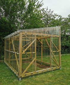 a small wooden structure in the middle of some grass