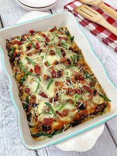 a casserole dish with green beans, cheese and bacon in it on a wooden table