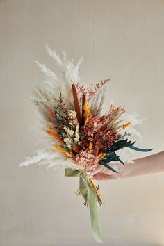 a person holding a bunch of flowers in their hand