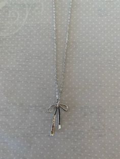 "Sleek and pretty silver tone bow knot necklace.  Simplistic design makes it a versatile piece for any outfit.   Pendant measures 1 1/4\" L X 3/4\" W and is on an 18\" chain.   ★ Want to see more?  Please visit my shop at: https://www.etsy.com/shop/DesignsByPeg" Silver Sterling Silver Necklace With Bow, Dainty Silver Necklace With Bow, Silver Jewelry With Satin Bow For Gifts, Silver Jewelry With Satin Bow As Gift, Minimalist Silver Jewelry With Bow, Adjustable Silver Necklace With Ribbon, Silver Adjustable Necklace With Ribbon, Adjustable Silver Necklace With Bow, Bow Pendant