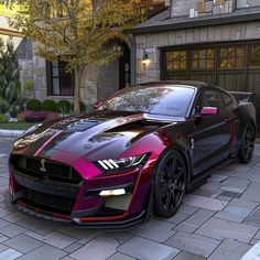 a red and black sports car parked in front of a house