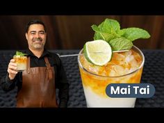 a man holding up a glass filled with ice and limes next to a mojit