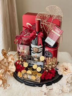 a red gift basket with wine, chocolates and cookies