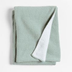 a green towel with a white stripe on the side and a light blue blanket behind it